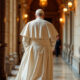 Papa Francisco caminha sozinho por um corredor ornamentado do Vaticano, vestindo batina branca tradicional e solidéu, com iluminação suave destacando os detalhes arquitetônicos ao fundo.