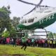 Homem se pendurando em helicóptero