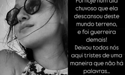 Imagem em preto e branco de uma jovem usando óculos escuros, com o cabelo solto e ao vento, olhando levemente para cima. Ela veste uma blusa estampada e está iluminada pela luz natural. Ao lado direito da imagem, há um texto de homenagem