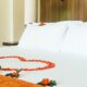 Cama de motel com pétalas de rosa em formato de coração