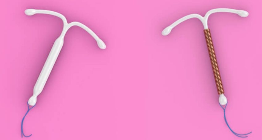 Dois modelos de dispositivo intrauterino (DIU) sobre fundo rosa: à esquerda, um DIU hormonal de plástico branco; à direita, um DIU de cobre com fio espiralado.