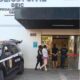 Policiais civis escoltam um homem e uma mulher algemados até a entrada de um prédio da Polícia Civil de São Paulo. Ao lado, viatura preta com o emblema da corporação. Fachada do prédio exibe a sigla DEIC (Departamento Estadual de Investigações Criminais).