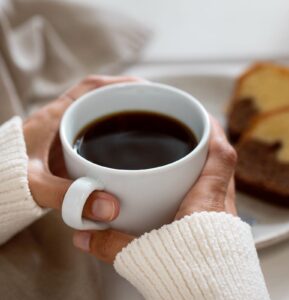 Mãos segurando xícara de café