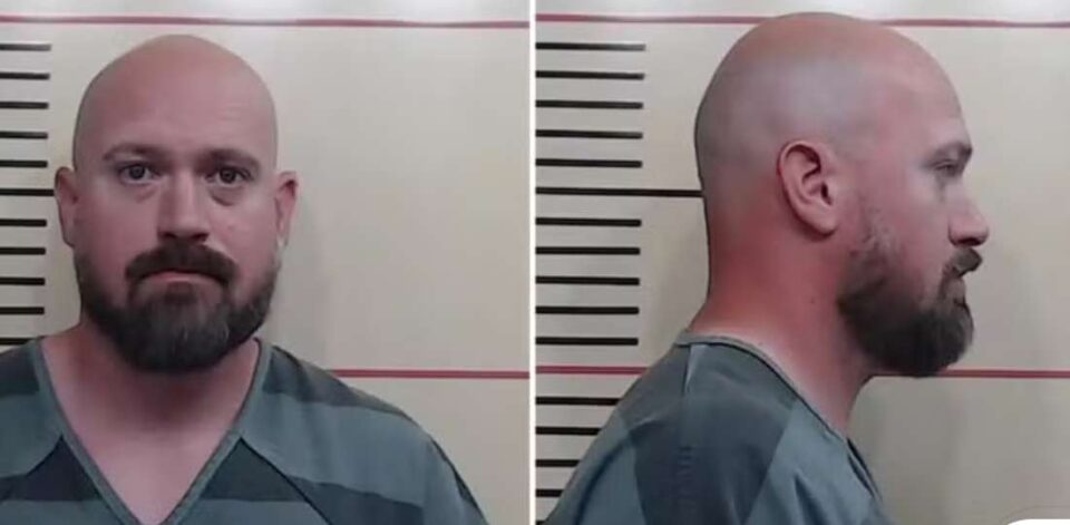 Foto de Justin Banta, homem branco, careca e com barba, vestindo uniforme de presídio. Ele aparece em duas poses: de frente e de perfil, em imagem de ficha policial