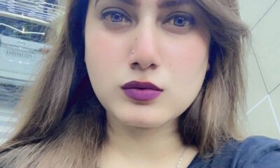 Retrato de Kanchan Kumari, influenciadora indiana de 30 anos, com cabelo castanho claro, batom roxo escuro e tatuagem visível no pescoço, tirado em ambiente moderno com luzes no teto