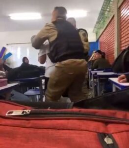 Policial tirando aluno de sala de aula