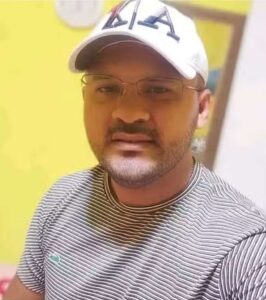 Selfie de Gilson Ferreira de Moura com camiseta cinza e boné