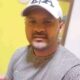 Selfie de Gilson Ferreira de Moura com camiseta cinza e boné