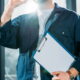 Homem com prancheta em ambiente de trabalho