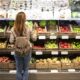 Mulher de frente para a prateleira escolhendo alimentos