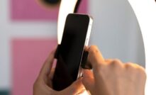 Celular sendo posicionado em frente à luminária