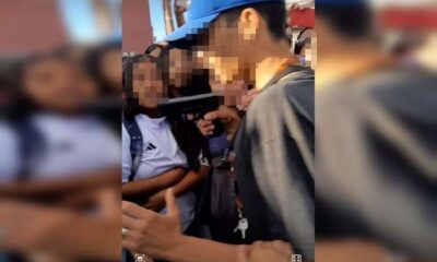 Jovem apontando arma para estudante