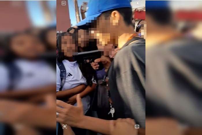 Jovem apontando arma para estudante