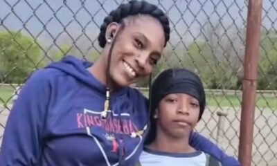 Mãe abraça o filho de 11 anos, ambos com roupas de frio, olhando para a câmera, ela sorri enquanto ele mantém expressão séria.