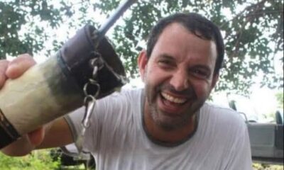 Piloto Marcelo Pereira de Barros está de blusa branca e sorrindo para a câmera. Ele segura uma cuia de chimarrão, bebida típica do Sul do Brasil.