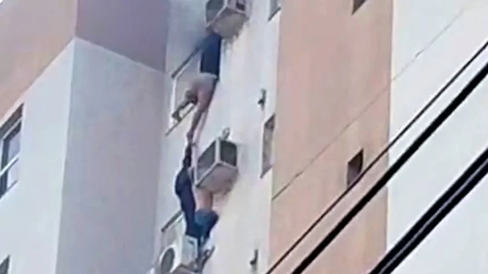 Mulher se pendura em ar-condicionado em incêndio