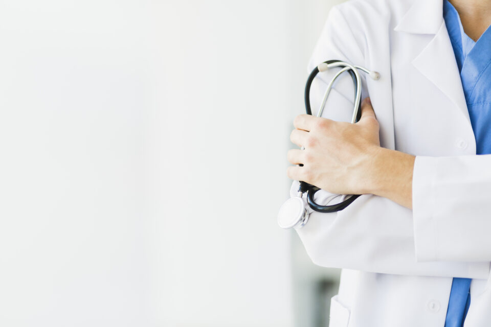 Imagem mostra braço do médico segurando estetoscópio.
