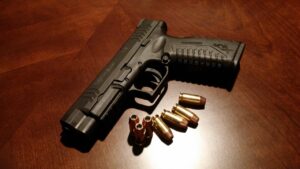 Arma com balas sobre mesa