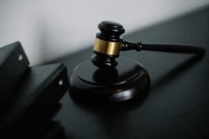 Martelo da justiça sobre superfície neutra, simbolizando julgamento, condenação e aplicação da lei.