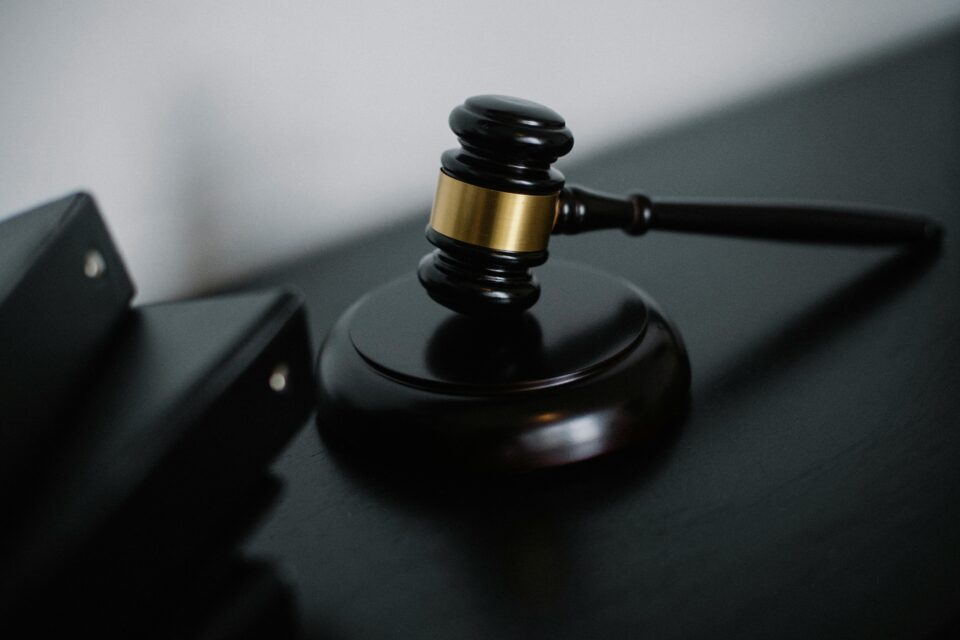Martelo da justiça sobre superfície neutra, simbolizando julgamento, condenação e aplicação da lei.