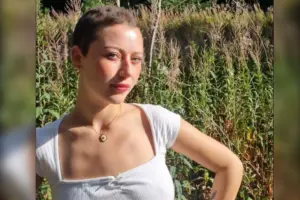 Mulher jovem de blusa branca e cabelo curto.