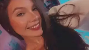 Mulher jovem de cabelo liso escuro e com roupas neutras.