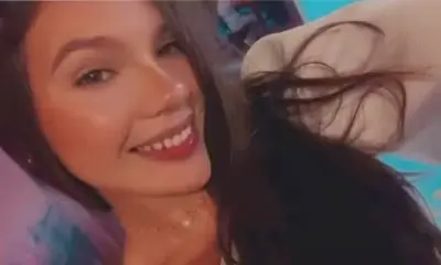 Mulher jovem de cabelo liso escuro e com roupas neutras.